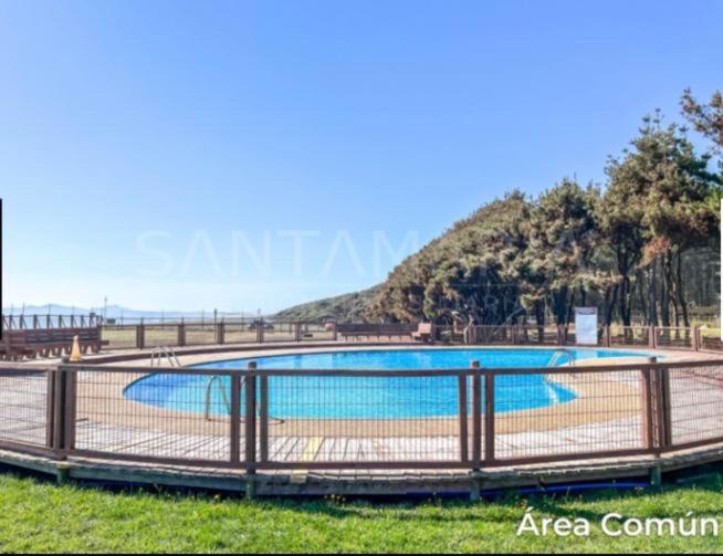 een groot zwembad met een hek eromheen bij Depto con acceso a playa privada in San Pedro de la Paz