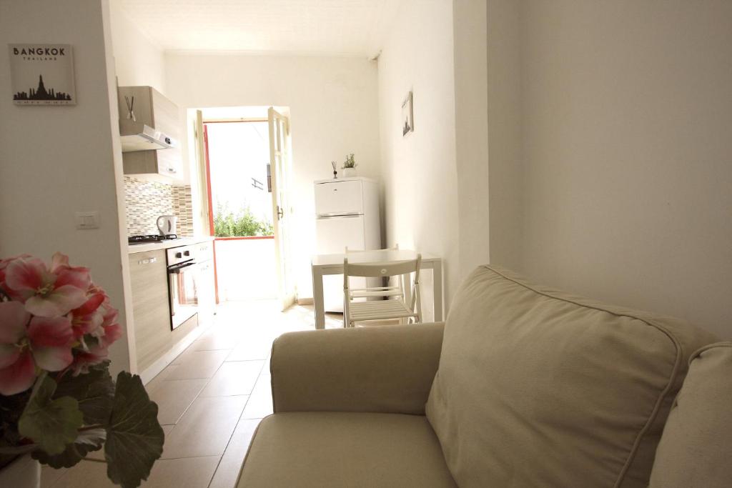 a living room with a couch and a kitchen at Simona Beach Holiday House in Anzio
