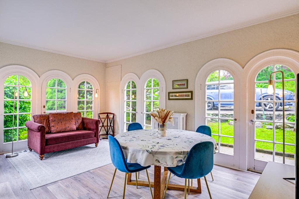 Un comedor con una mesa y sillas azules. en Historic Mamaroneck Guest House - Walk to Harbor!, en Mamaroneck