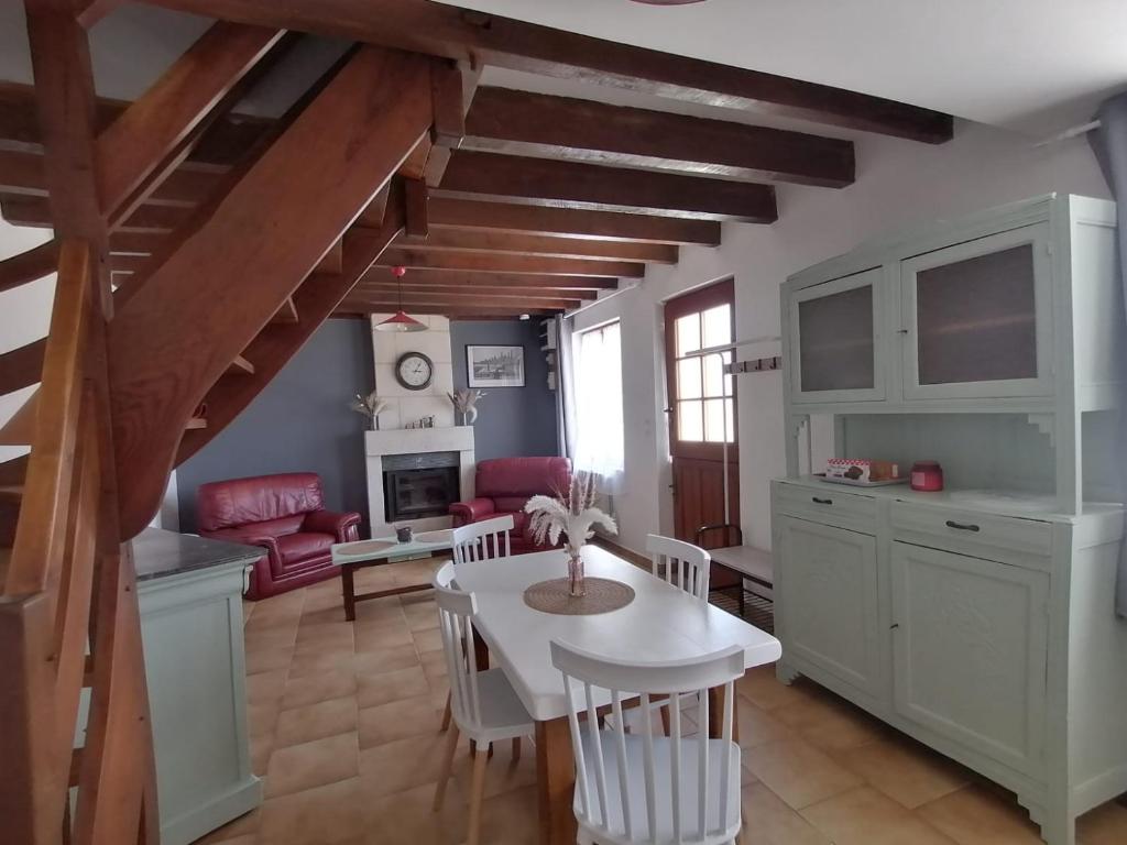 eine Küche und ein Wohnzimmer mit einem weißen Tisch und Stühlen in der Unterkunft MA SOLOGNE,ZOO BEAUVAL,CHATEAUX DE LA LOIRE,GOLF in Sassay