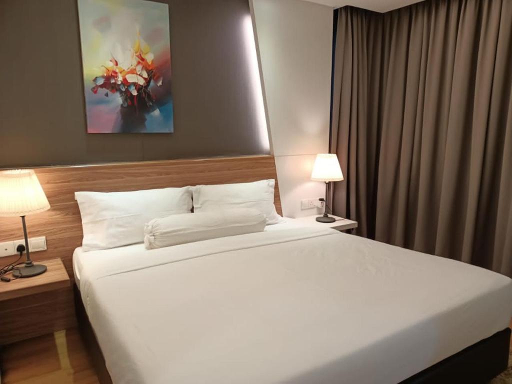 - une chambre avec un grand lit blanc et deux lampes dans l'établissement Royal Suite, à Kuala Lumpur