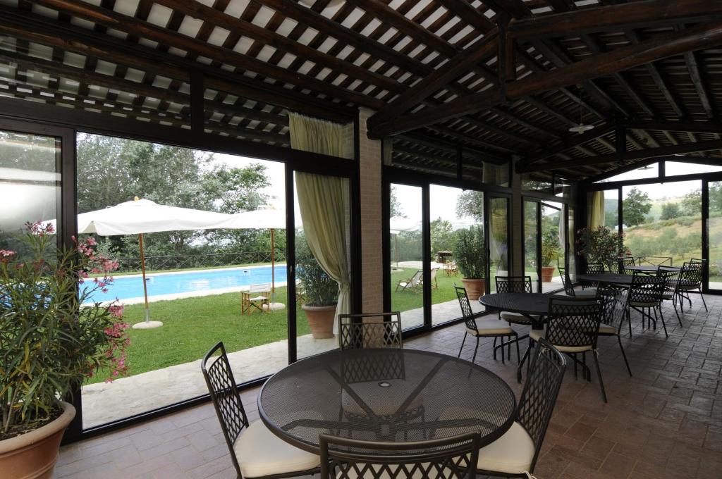 une terrasse avec des tables et des chaises ainsi qu'une piscine dans l'établissement Agriturismo Le Case, à Assise