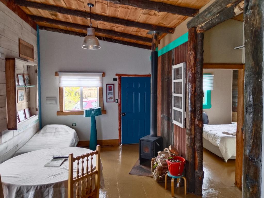1 dormitorio con 2 camas y puerta azul en Cabañas Juan Jose, en Piruquina