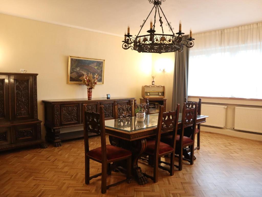 comedor con mesa, sillas y lámpara de araña en Kesletz House, en Sibiu