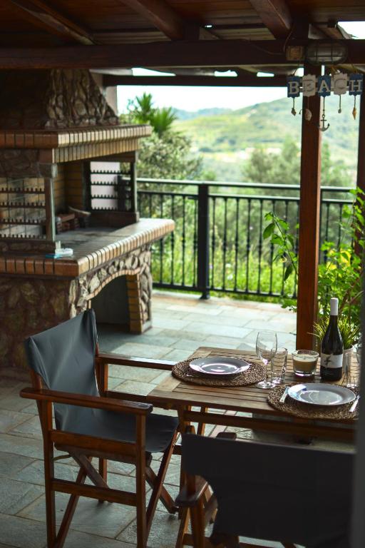 a table and chairs on a patio with a fireplace at Petralia's Guest House in Skiathos