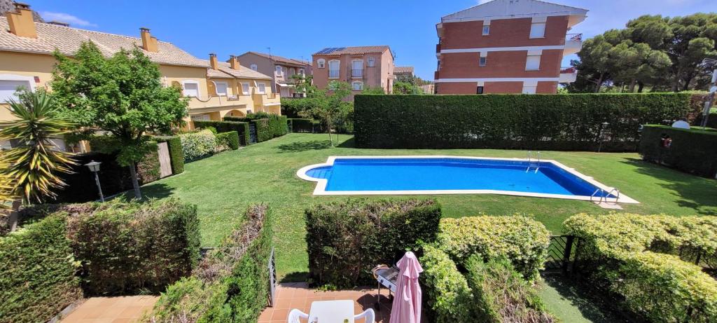a swimming pool in a yard with bushes and buildings at Casa Estartit Oest 6A R in L'Estartit