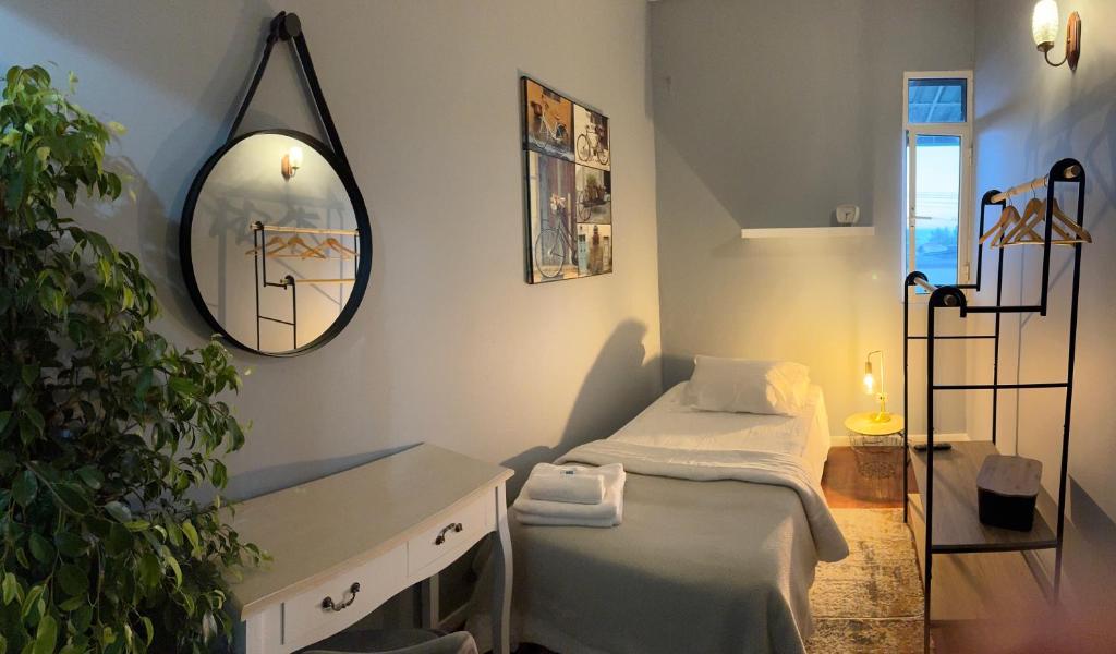ein kleines Zimmer mit einem Bett und einem Spiegel in der Unterkunft Residencial Funchal in Funchal