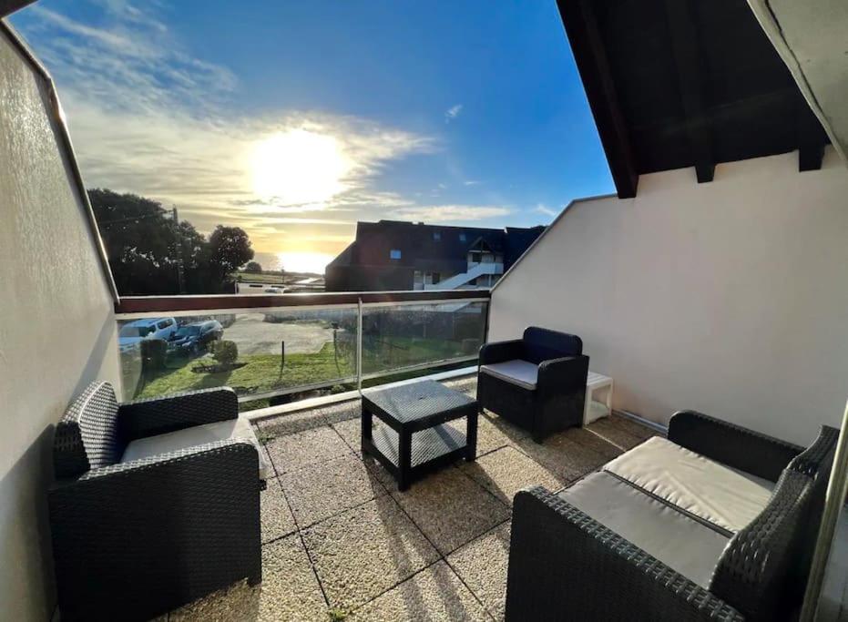 d'un balcon avec des canapés, une table et une vue. dans l'établissement Magnifique duplex vue océan au cœur de la station, à Carnac