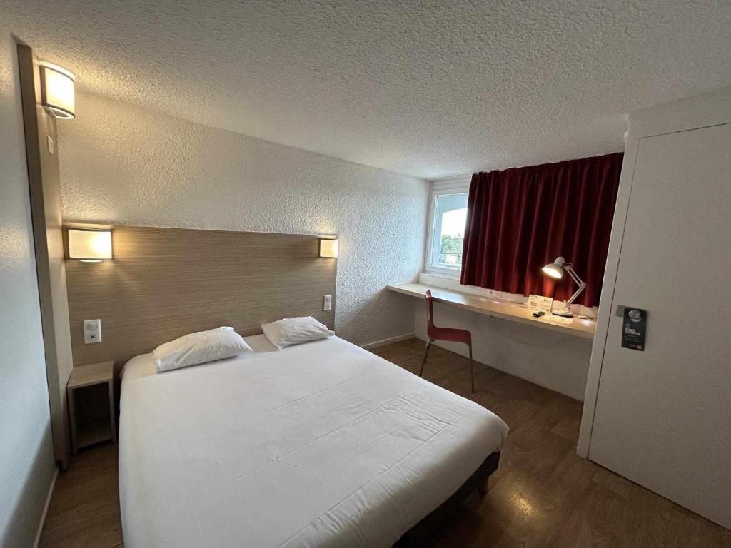 ChaintréにあるPremière Classe Mâcon Sudの白いベッドと窓が備わるホテルルームです。
