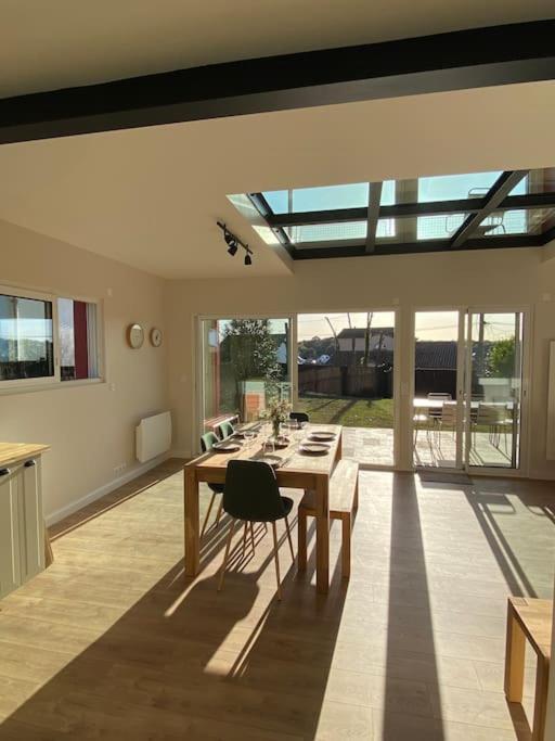 une salle à manger avec une table, des chaises et des fenêtres dans l'établissement Vue Mer 2 pas des plages 10 pers 4 chambres Villa KER LOT PLAGE, à Saint-Nazaire