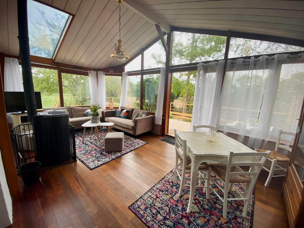 un salon avec une table et des chaises blanches dans l'établissement Grand Gîte CLIMATISE Ma Maison de Vacances proche de La Rochelle 10 personnes, à Saint-Médard-dʼAunis