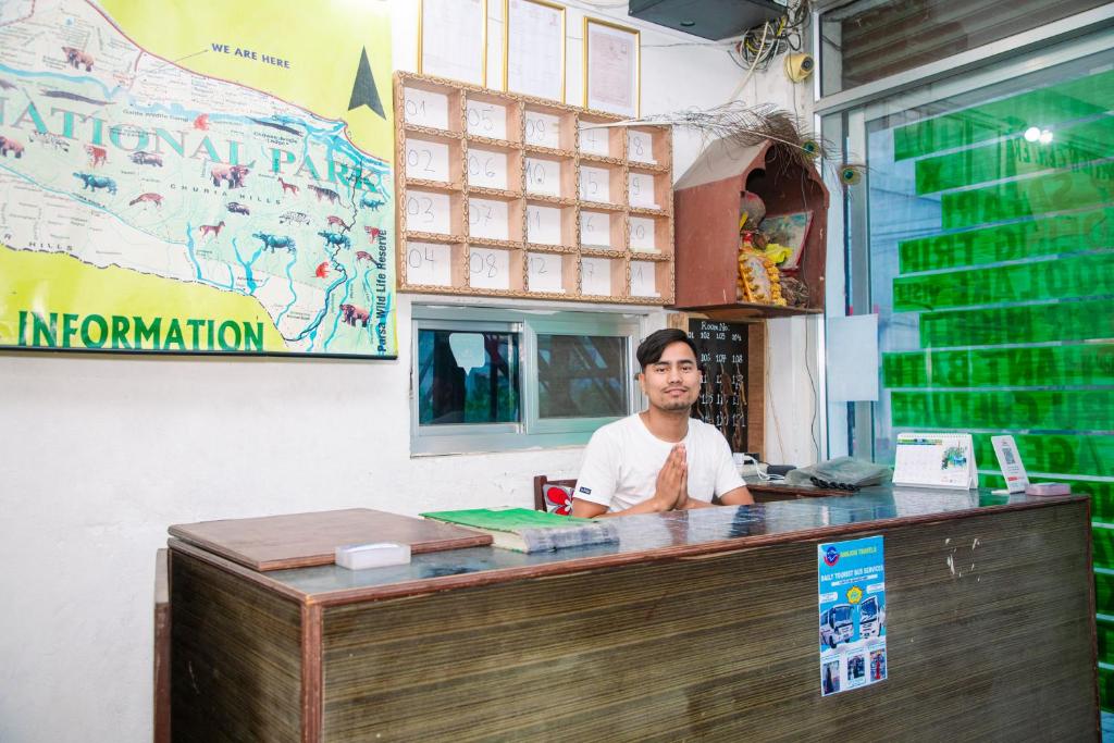 a man sitting at a counter in a restaurant at Hotel Shiva's Dream in Sauraha