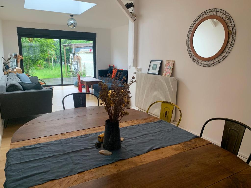 une table à manger avec un vase au-dessus dans l'établissement Maison avec jardin à Lille Bois Blancs, à Lille