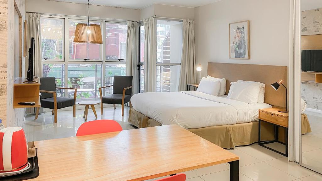 ブエノスアイレスにあるFeel Buenos Aires Apartmentsのベッドとダイニングルームが備わるホテルルームです。