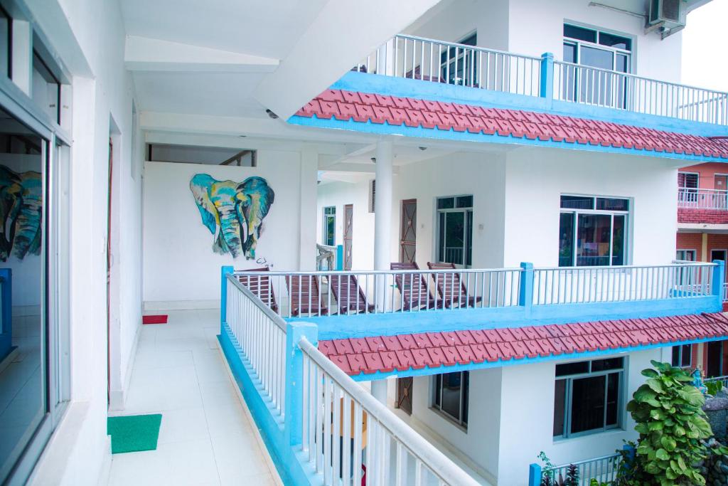 an apartment building with blue balconies with an elephant painted on the wall at Hotel Shiva's Dream in Sauraha
