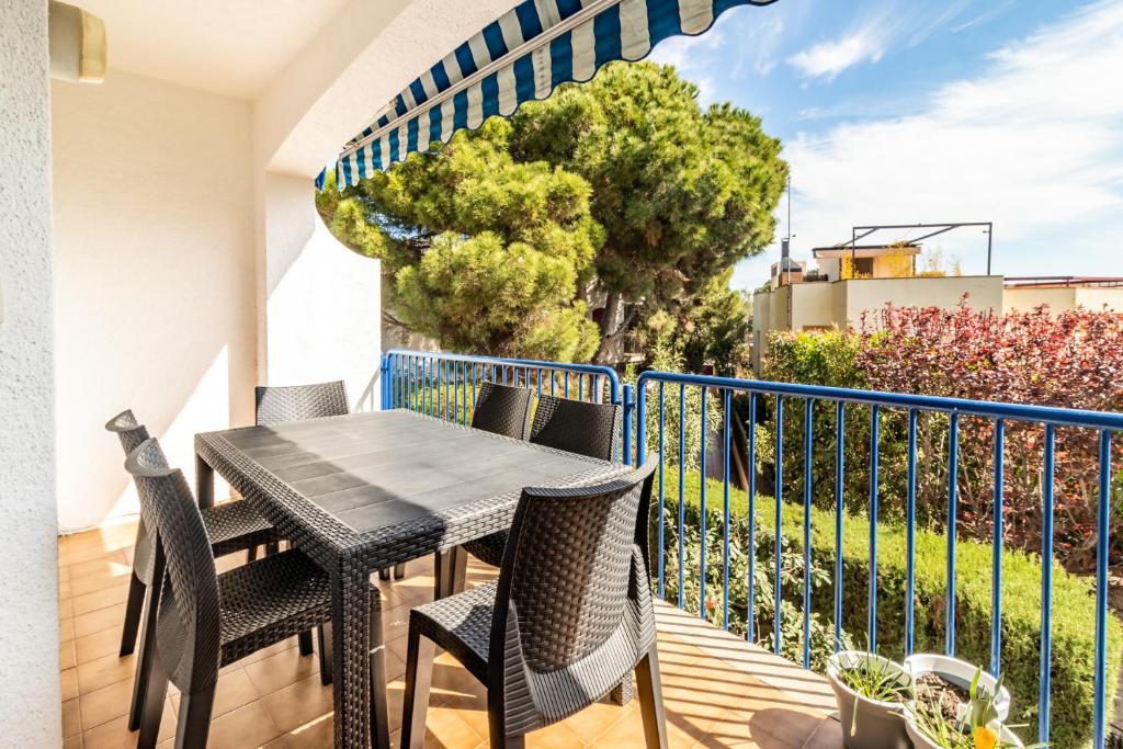 een patio met een tafel en stoelen op een balkon bij Carboneras 54 Apartamento acogedor cerca del mar in Girona
