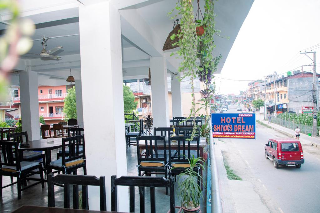 a restaurant with tables and chairs and a sign that reads hotel savings program at Hotel Shiva's Dream in Sauraha