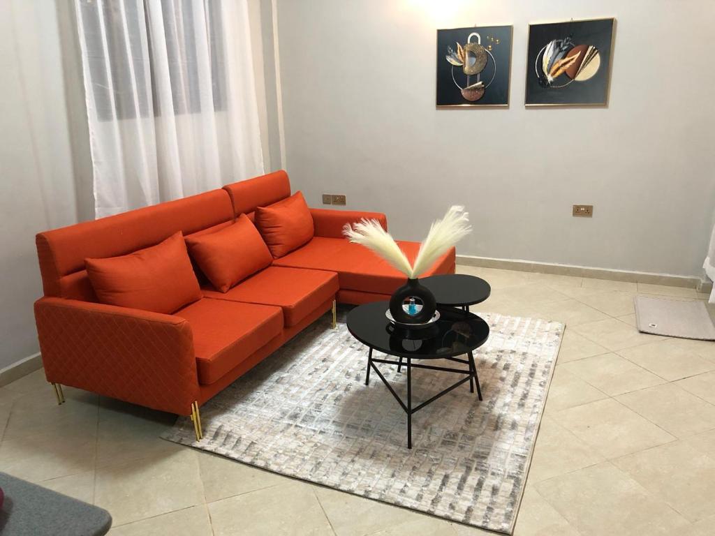 a living room with a orange couch and a table at JnB Naivasha town 1Bedroom in Naivasha