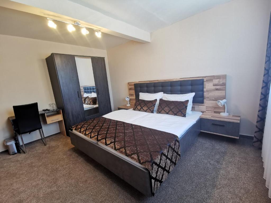 a bedroom with a large bed and a mirror at Hotel Art Balkanhof in Gelsenkirchen