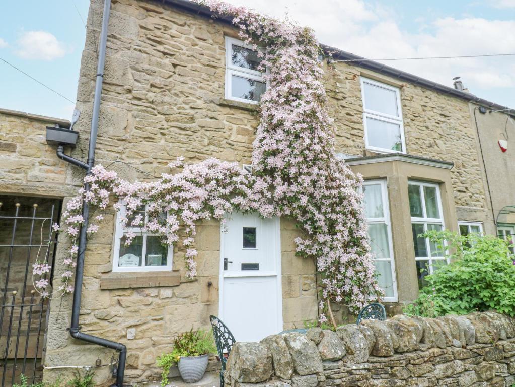 a stone house with flowers on the front of it at Wayside Cottage in Consett