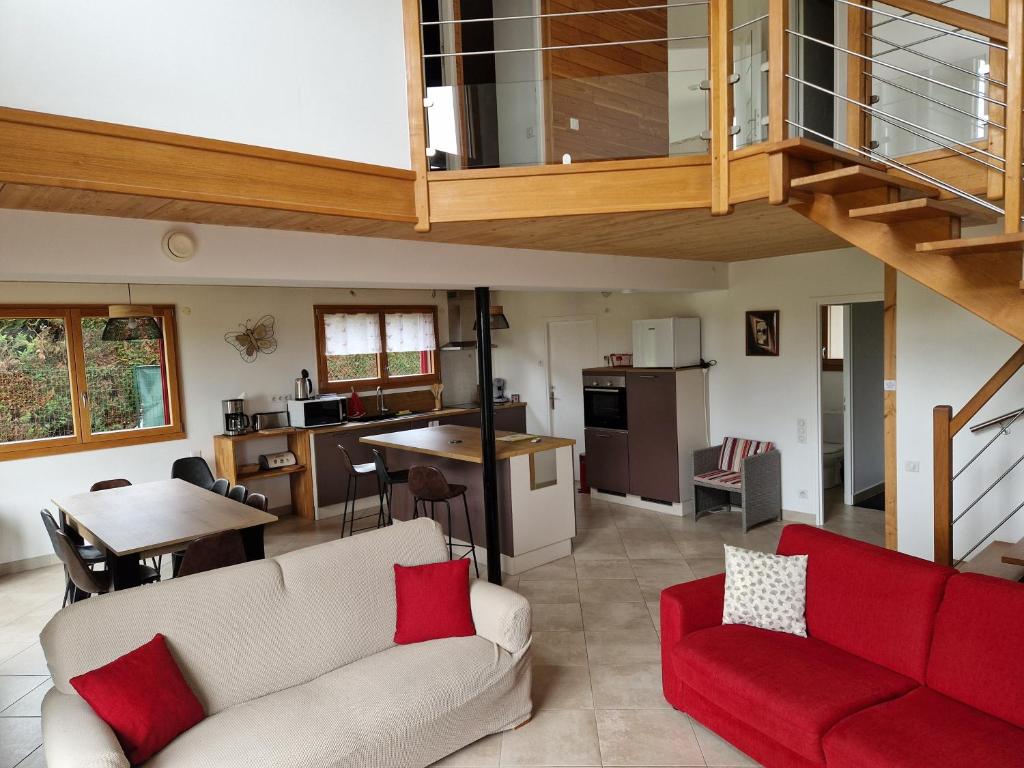 sala de estar con sofá rojo y cocina en Gite entre Loire, châteaux et Sologne, en Saint-Claude-de-Diray