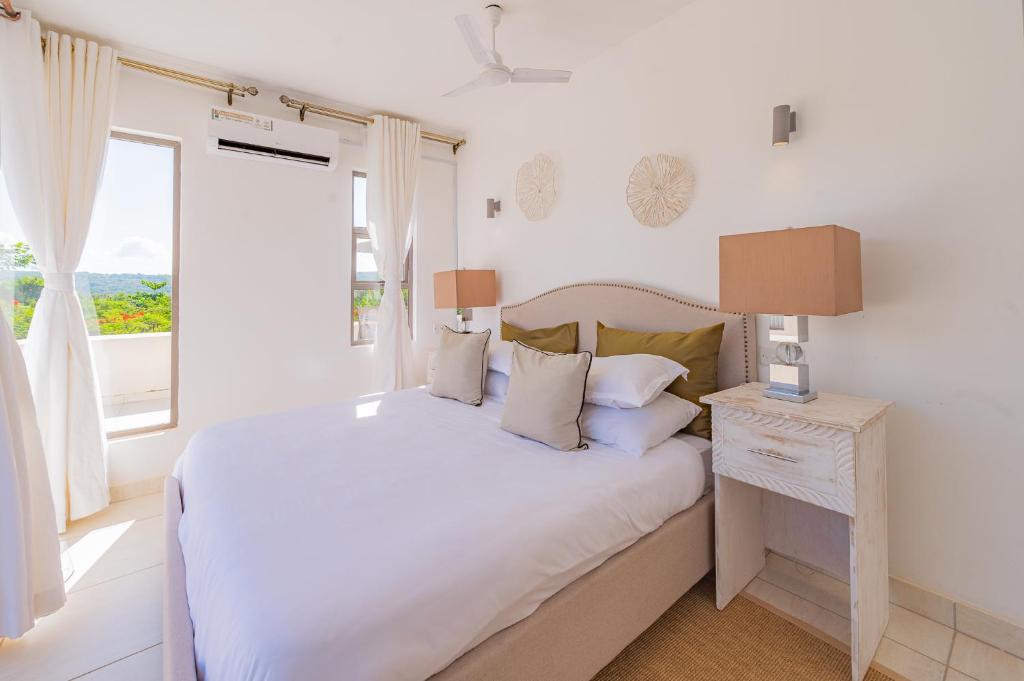 Postel nebo postele na pokoji v ubytování Insigma Kuza Villas