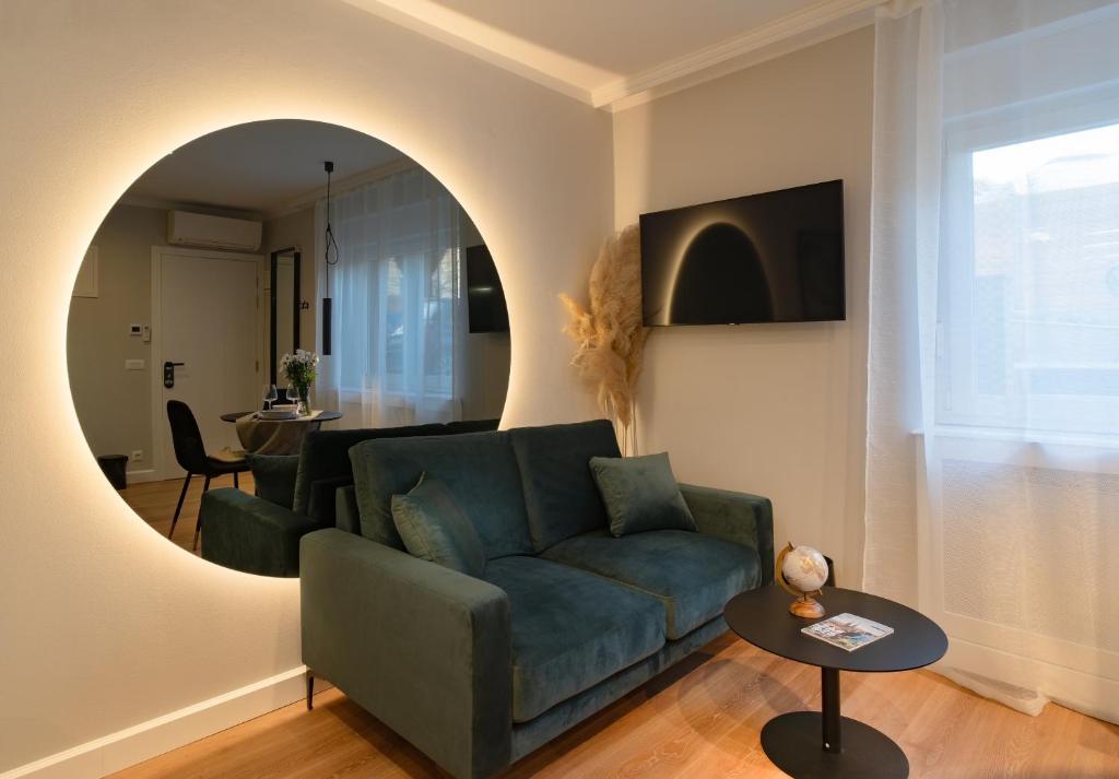 een woonkamer met een blauwe bank en een spiegel bij Apartments and More in Zagreb