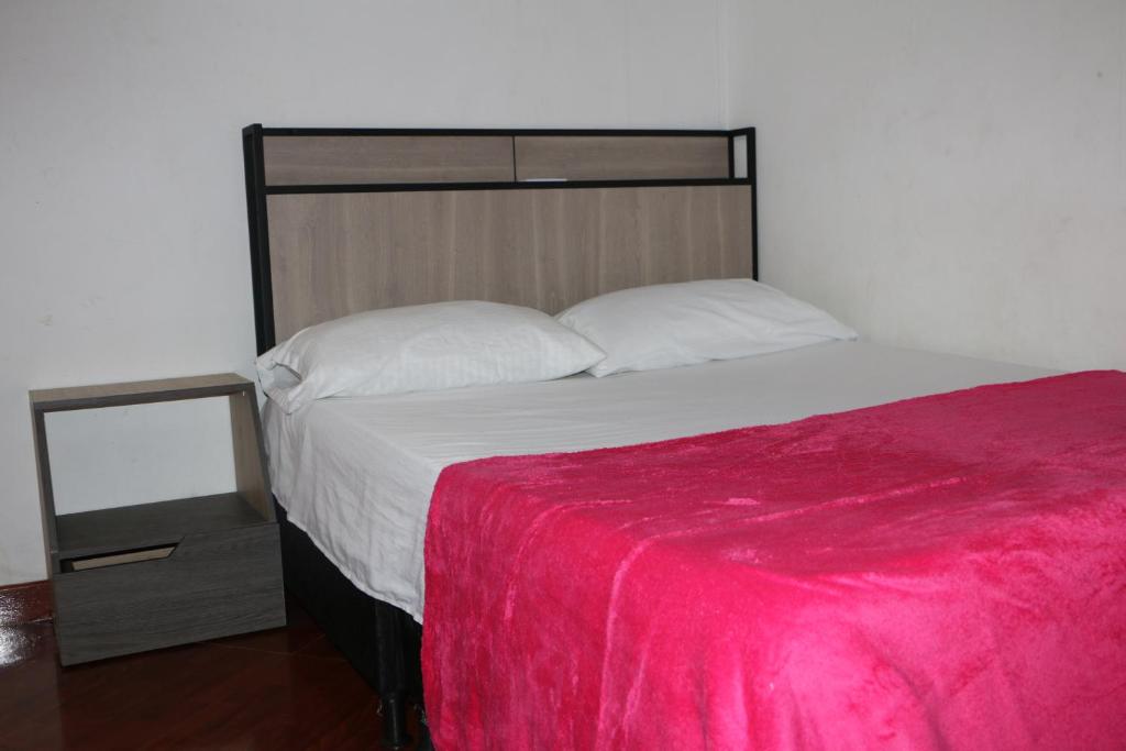 1 dormitorio con 1 cama grande con manta roja en Aparta Suite Torre De Prado 305 en Medellín