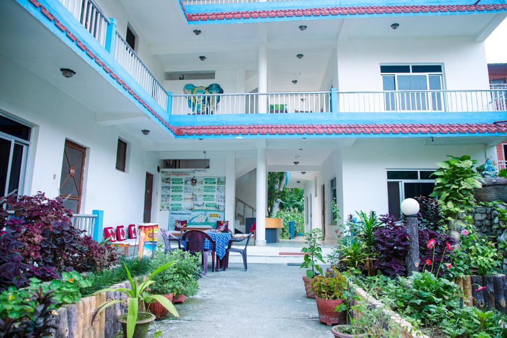 a house with a balcony and a table and chairs at Hotel Shiva's Dream in Sauraha