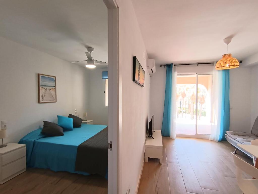 um quarto com uma cama azul e uma janela em AyF MODERNO Y LUMINOSO APARTAMENTO em Oropesa del Mar
