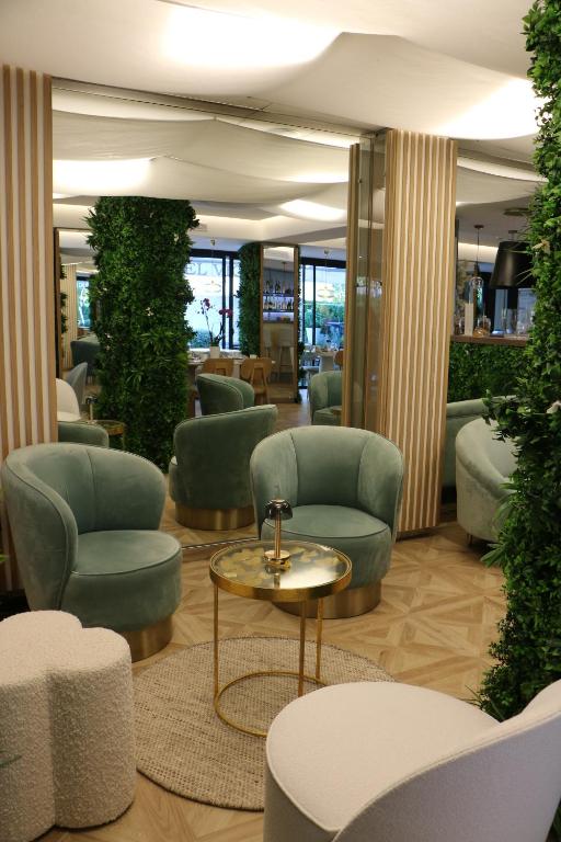 a lobby with green chairs and a table at Hôtel Victoria in Cannes