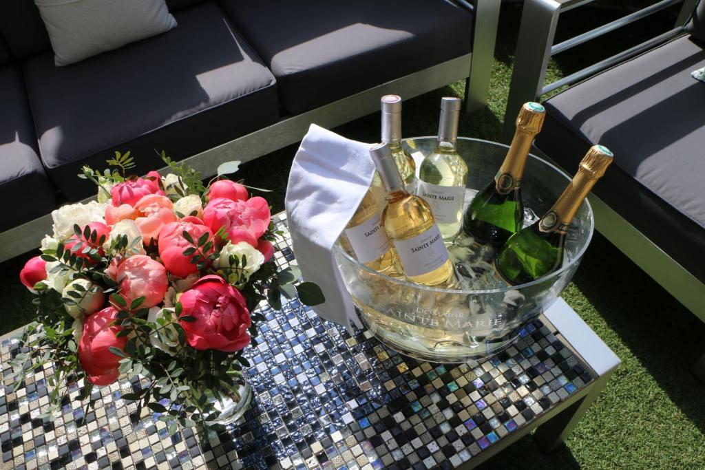 a table with two bottles of wine and flowers on it at Hôtel Victoria in Cannes