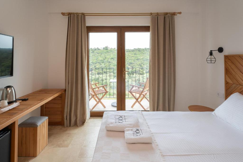 a hotel room with a bed and a balcony at TERRA GAİA Hotel in Gokceada Town