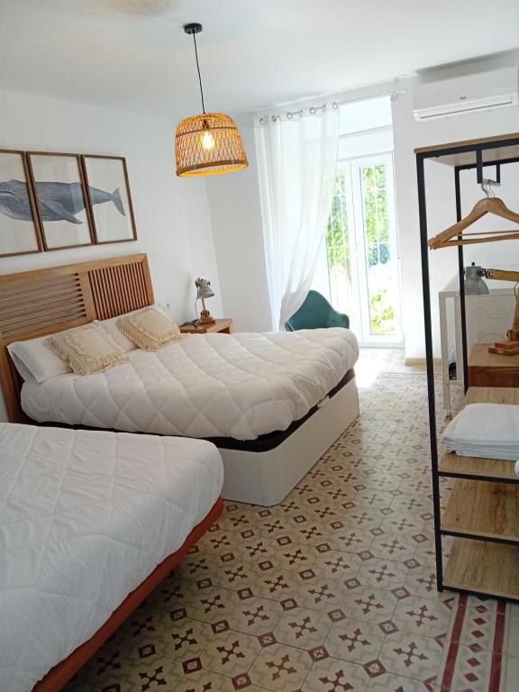 1 dormitorio con 2 camas y lámpara de araña en Apartamento Plaza San Francisco, en Trujillo