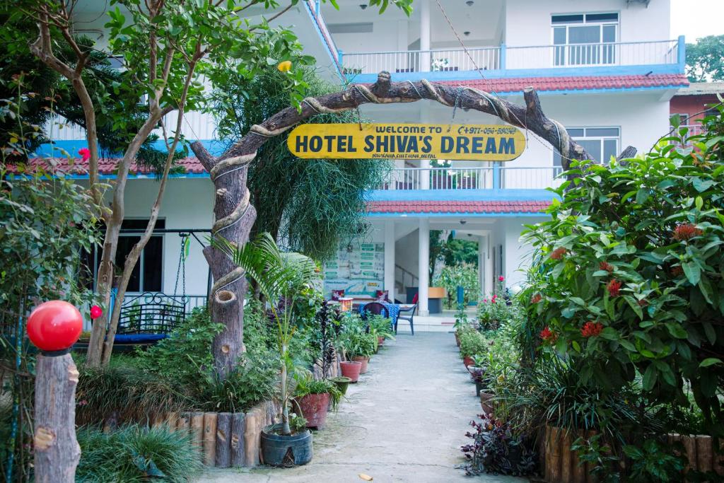 a sign in front of a hotel with plants at Hotel Shiva's Dream in Sauraha