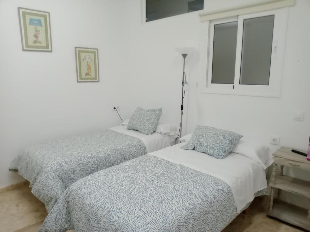 two beds in a room with white walls at SAN FELIPE in Carmona