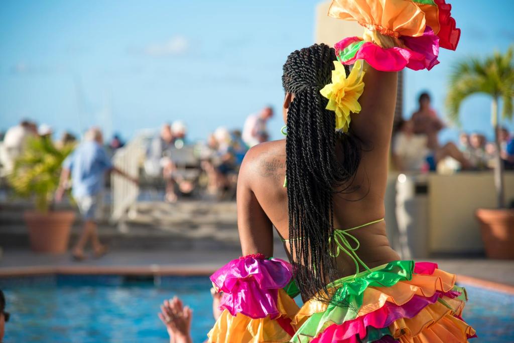 a woman in a bikini next to a swimming pool at Simpson Bay Resort Marina & Spa in Simpson Bay