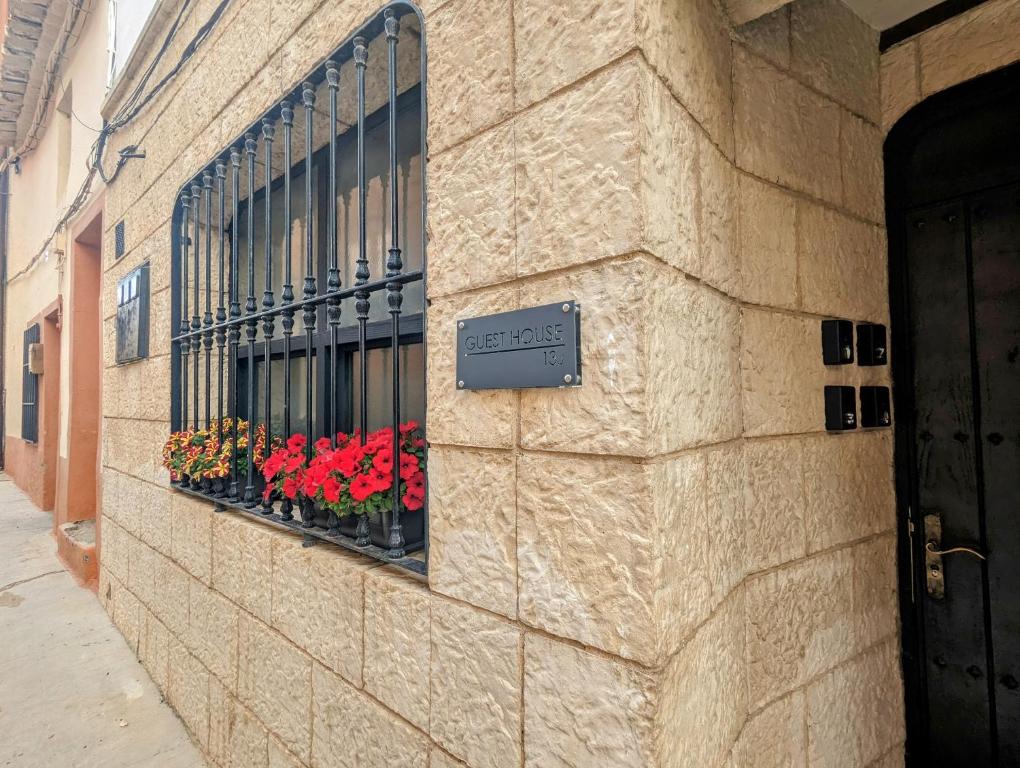 ein Gebäude mit einem Fenster mit Blumen darauf in der Unterkunft Alojamiento 13 Jotas in Iniesta