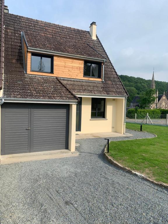 ein Haus mit Garage auf einer Kiesauffahrt in der Unterkunft La chapelle in Fervaches