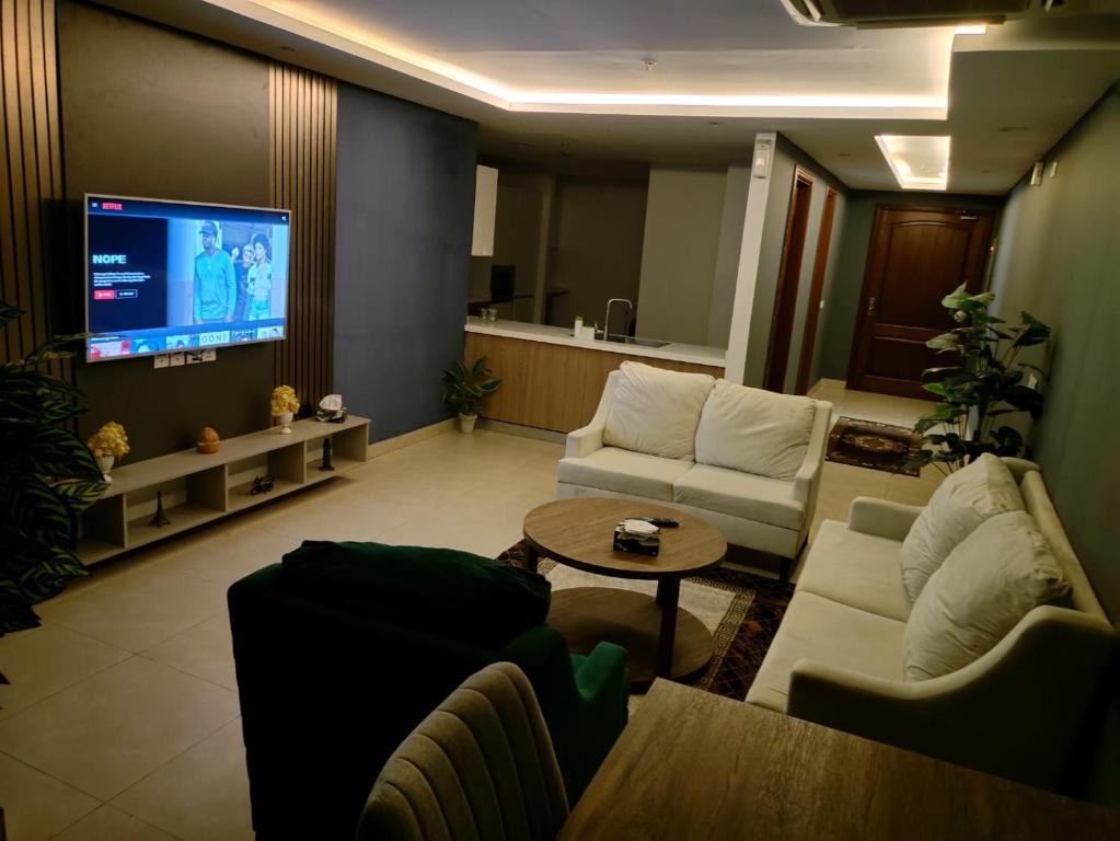 een woonkamer met banken en een flatscreen-tv bij One bed appartment in GOLDCrest DHA Lahore in Lahore