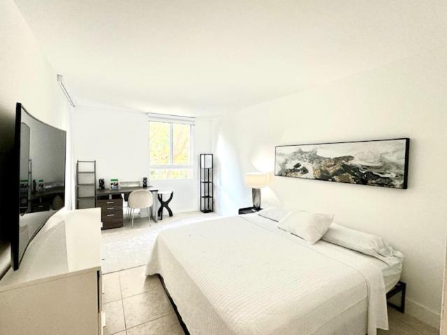 una camera bianca con letto e scrivania di best life a Miami
