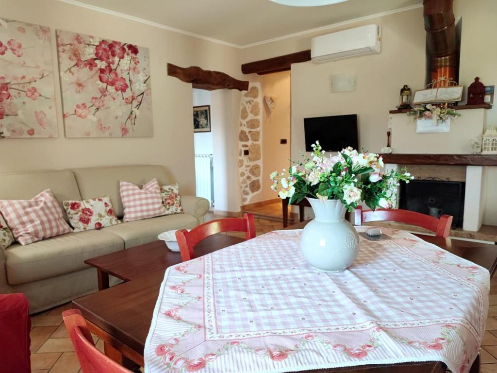 un soggiorno con tavolo e vaso di fiori di Il Bagolaro Casa Vacanze a Sulmona