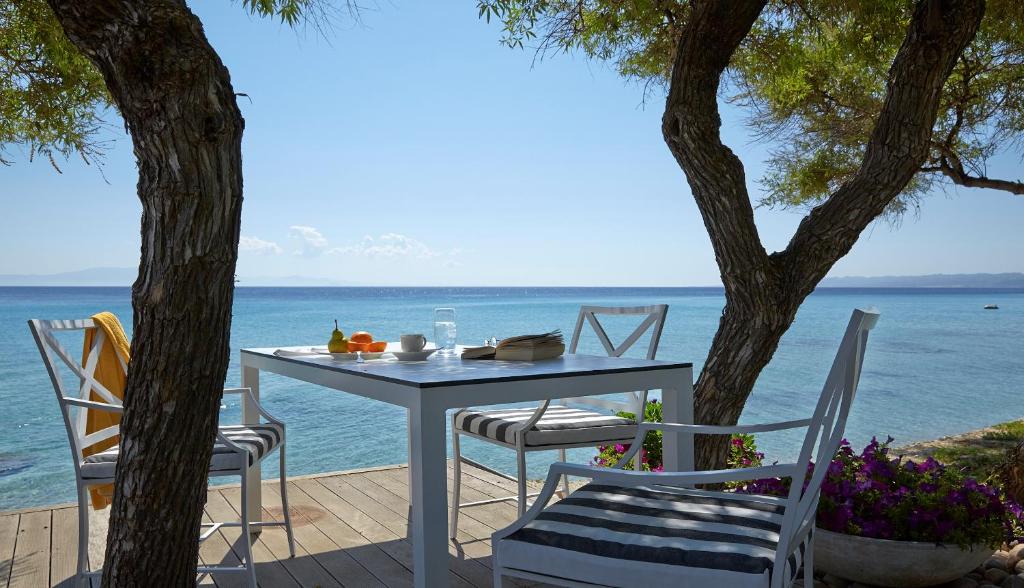 a table and chairs on a patio with the ocean at Afitis Boutique Hotel in Afitos