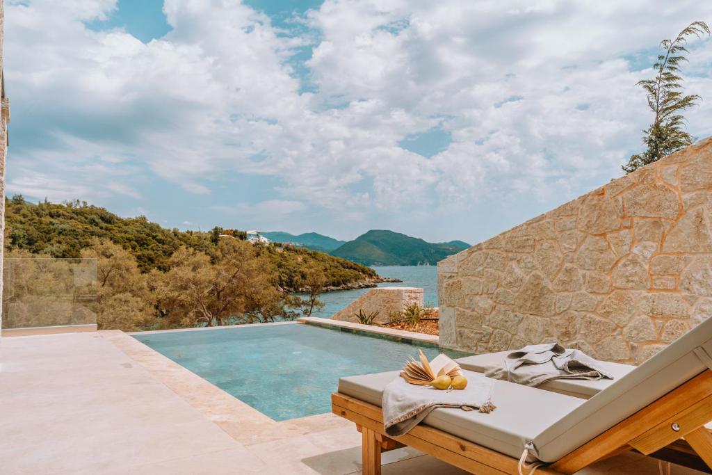 a villa with a pool and a view of the water at Gabbana Beach Villas in Syvota