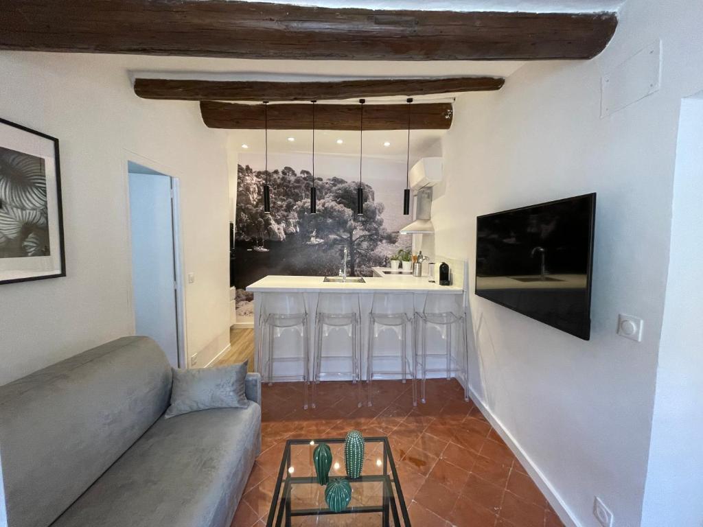 un salon avec un canapé et une cuisine dans l'établissement Mazarin Suite Centre ville historique proche cours Mirabeau, à Aix-en-Provence