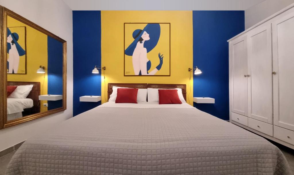1 dormitorio con 1 cama con paredes azules y espejo en io sciù sciù, en Santa Maria Capua Vetere