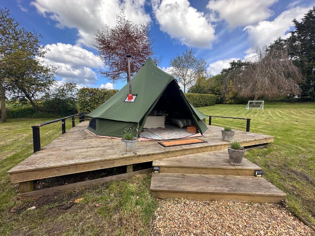 a green tent sitting on top of a wooden deck at Glen Farm Glamping in Cromer