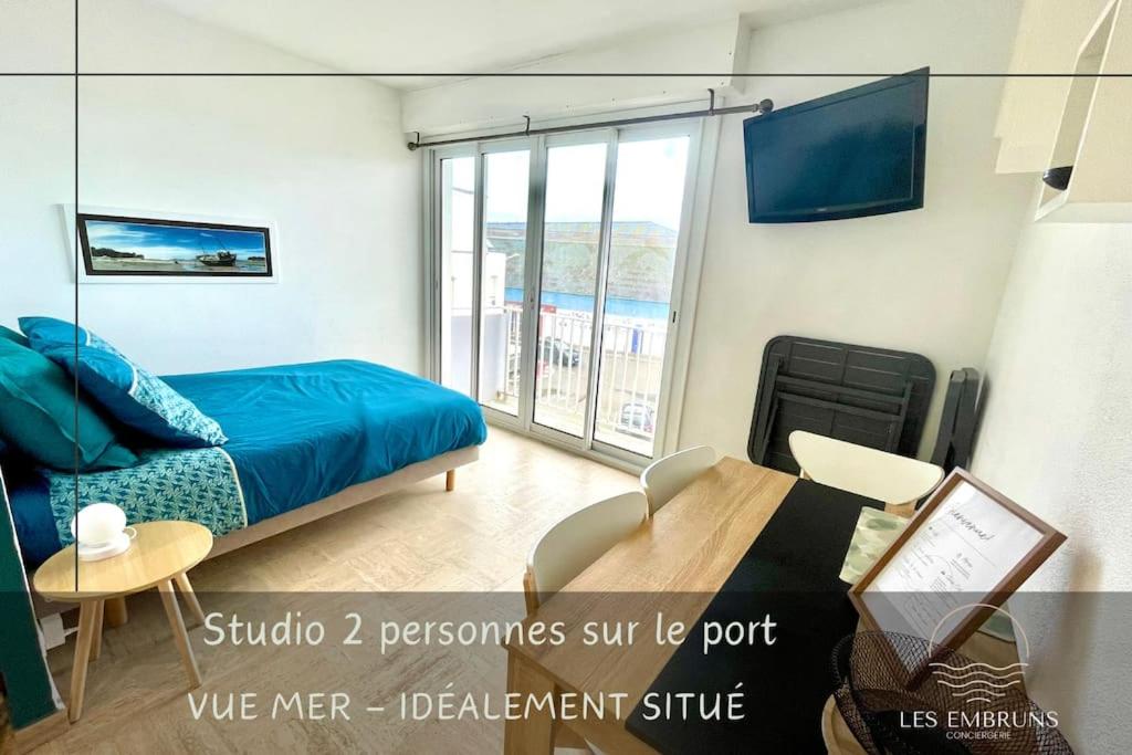 - une chambre avec un lit, une table et un balcon dans l'établissement Studio sur les quais d'Etel, à Étel