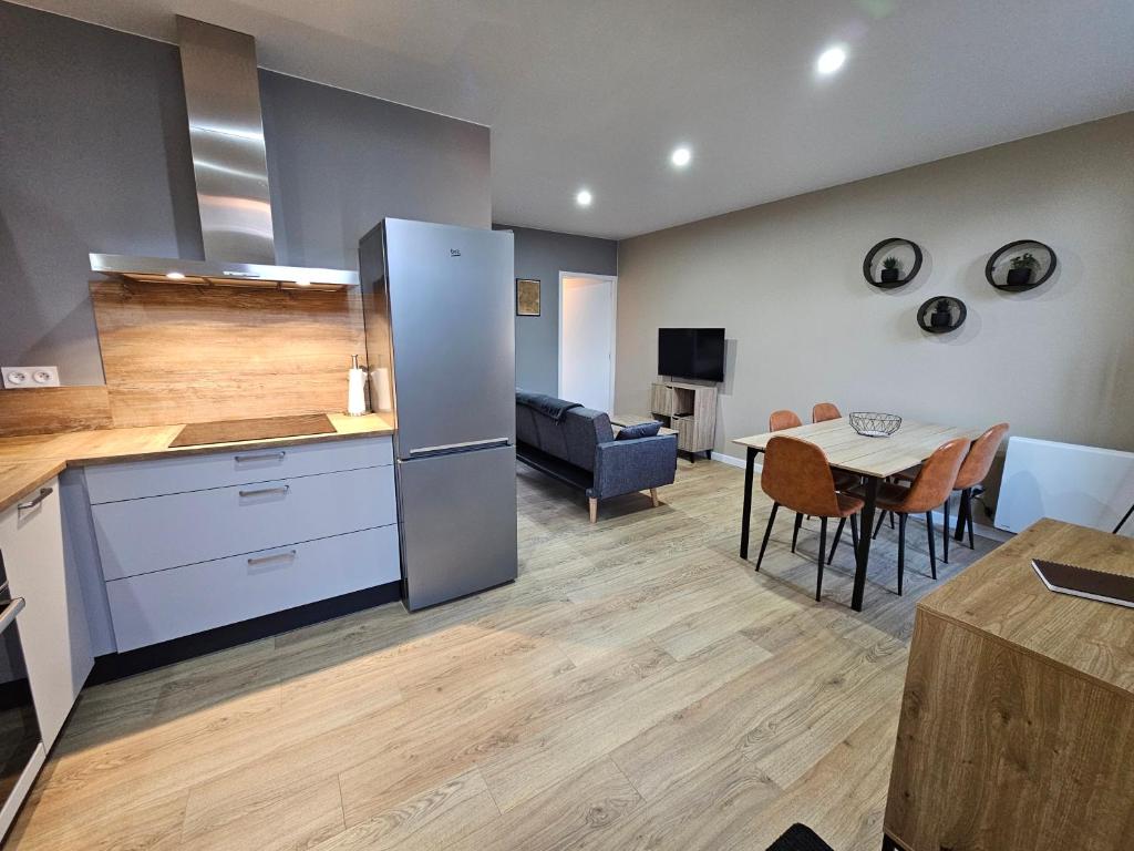 a kitchen and living room with a table and a couch at Appartement Le 96 in Lurcy-Lévis