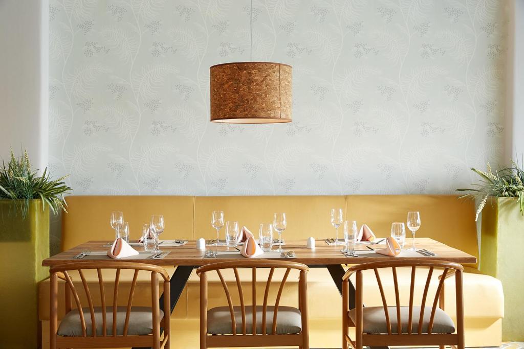 a wooden table with four chairs around it at Afitis Boutique Hotel in Afitos